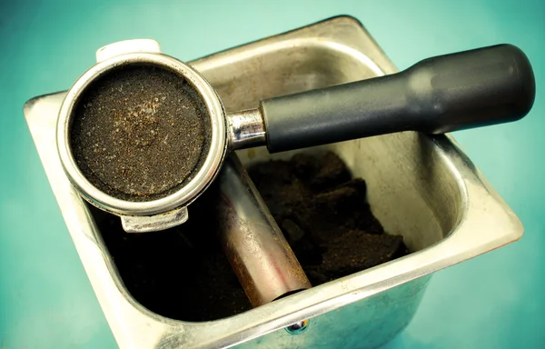 Portafilter with ground coffee on blue wooden table background