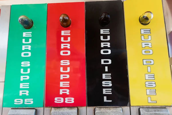 Green, red,black and yellow pump nozzles at the gas station