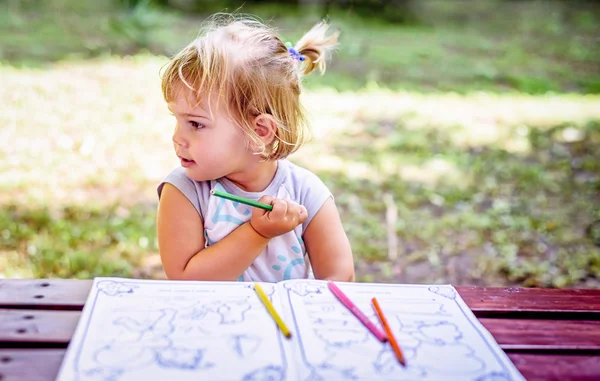 Beautiful Two year old girl drawing in a coloring book