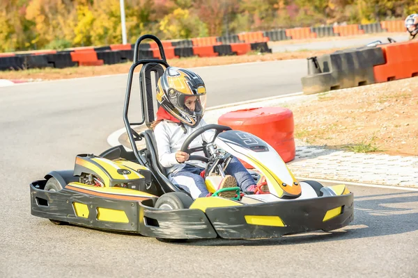 Little girls are driving Go- Kart car in a playground