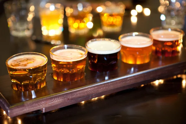 Set of glasses of light and dark beer on a pub background.