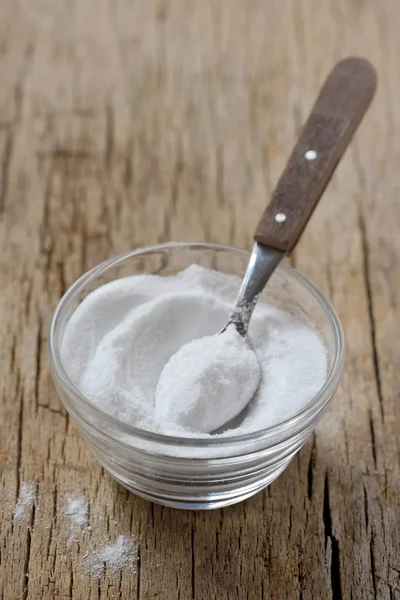 Spoon of baking soda in bowl of baking soda