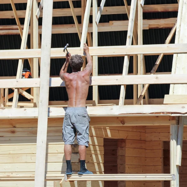 Work nailing boards with a hammer.