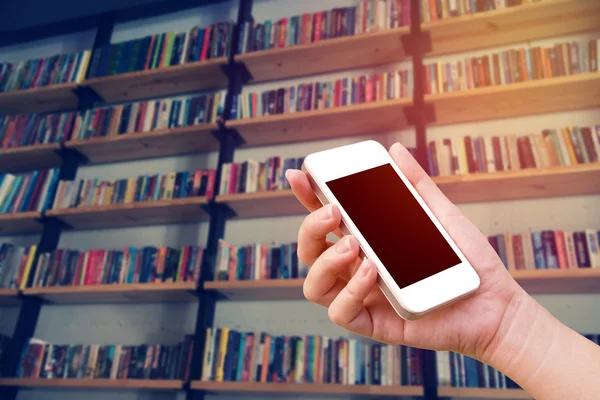 Woman hand using the phone tablet with book shelf background