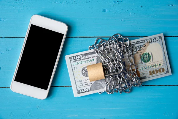 Phone and locked dollar money by metal chain link with padlock