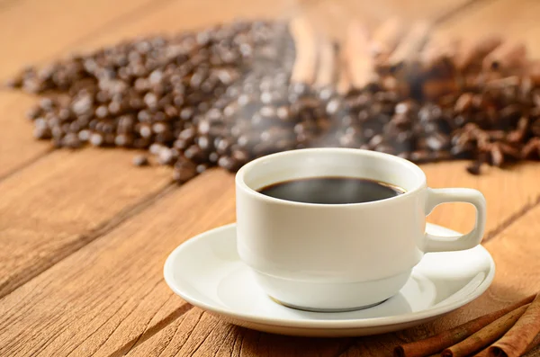 White coffee cup with smoke and coffee beans around