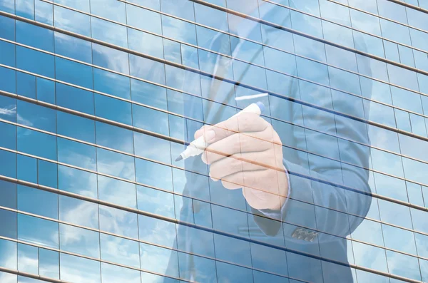 Business man use pen writing on virtual screen with modern glass window background