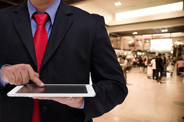 Business man holding tablet in hand in blur background