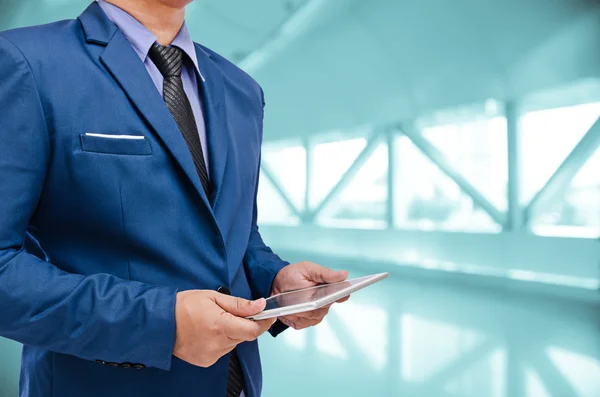 Business man holding tablet in hand in blur background