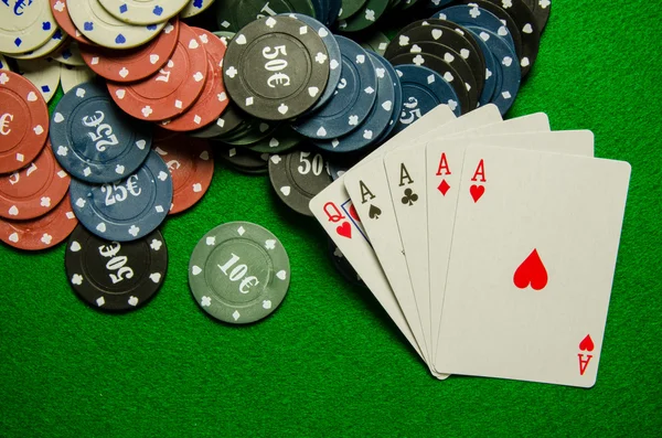 Playing cards 'Four of a kind' and chips on green background