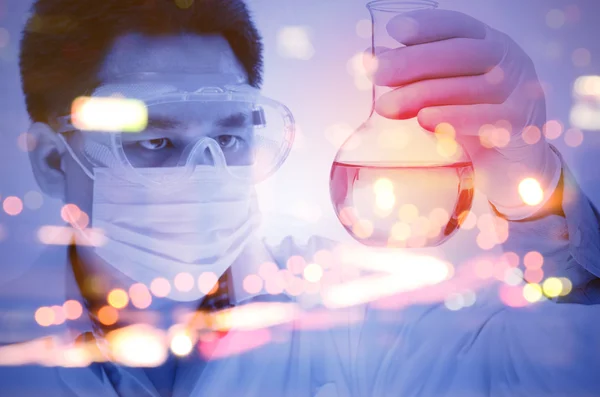 Double exposure of scientist hand holding laboratory flask