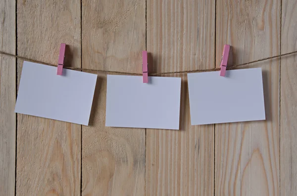 Empty white photo frames hanging with clothespins