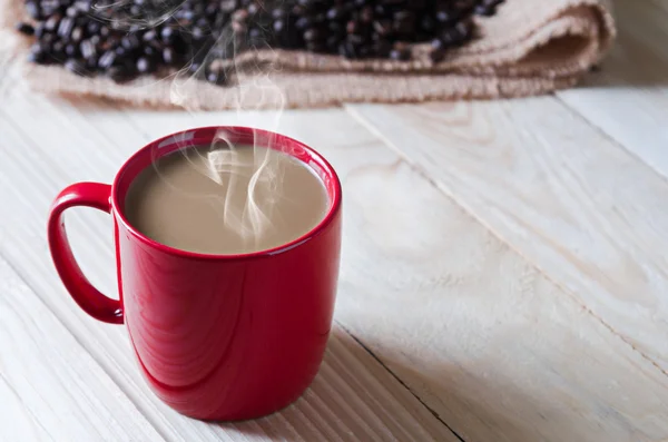 Coffee cup with smoke and coffee beans around