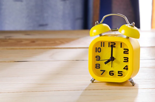 Yellow alarm clock on wood table