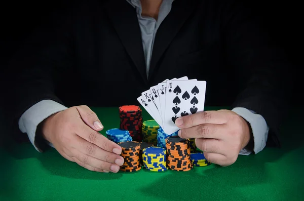Business man win poker game with royal flush in hand