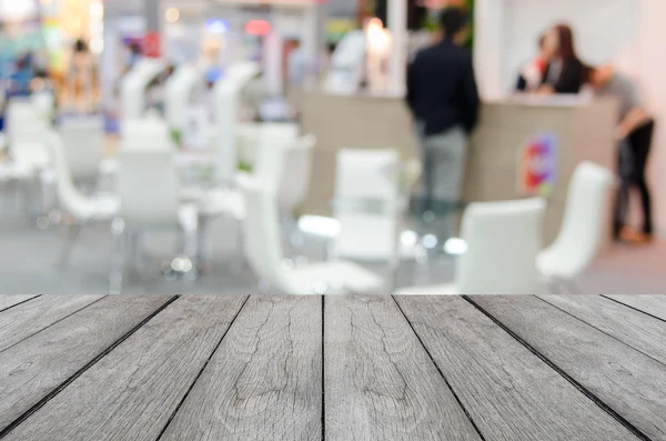 White wood table with blurred event background