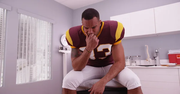 College football player waiting in doctor\'s office for bad news