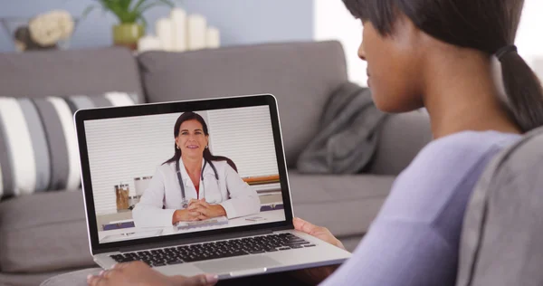 African American woman video chatting with doctor