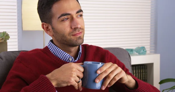 Mexican guy smiling and drinking his coffee