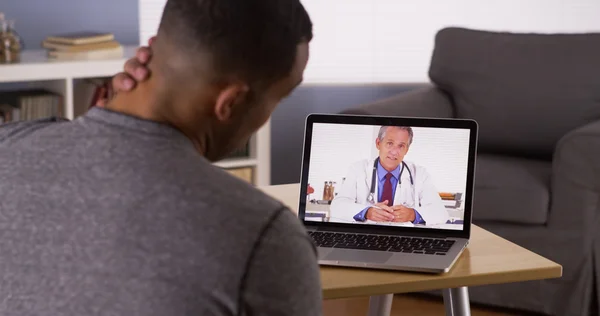 Black patient discussing health problems with doctor online