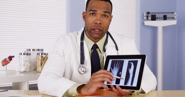 Black doctor listening and talking to camera