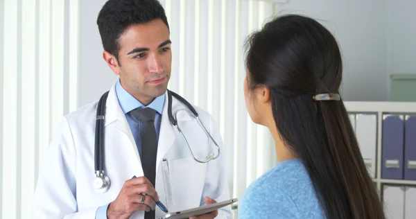 Chinese patient talking to hispanic doctor