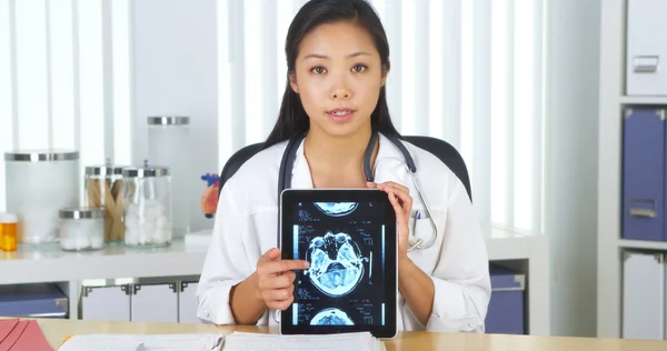 Chinese doctor talking to camera with tablet about xrays