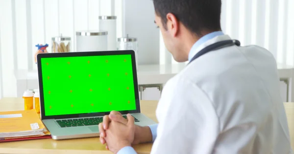 Mexican doctor talking to laptop with green screen