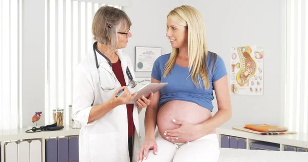 Pregnant woman talking with her doctor in the office
