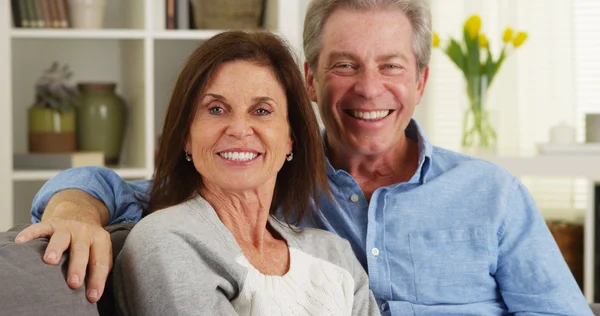 Senior couple laughing and talking to camera