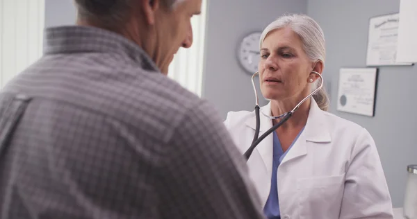 Doctor listening to patient\'s heart rate with stethoscope