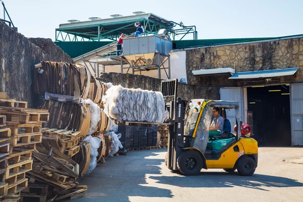 Forklift operator handling wooden pallets in warehouse