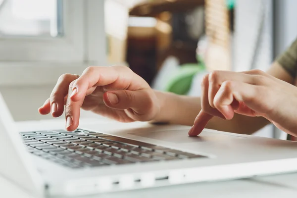 Womans hands working on laptop computer