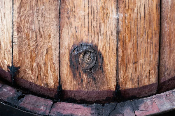 Close up of old oak wine barrel with wine drips, leak traces. Contents are leaking down the side of barrel.