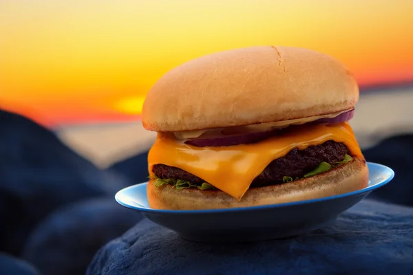 Cheese burger on beach rock