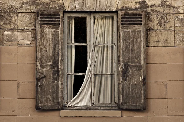 Old vintage window with open brown blinds and old used bricks.