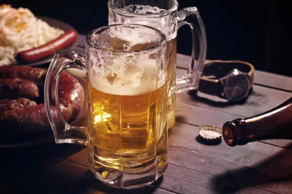 Beer in a glass on wooden background. Beer and beer snack.