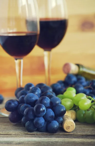 Two glasses with red wine, bottle of wine, grapes and wine traffic jams