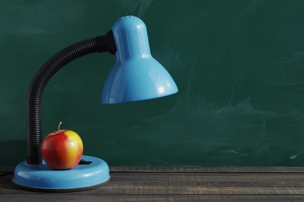 Desk lamp and red apple