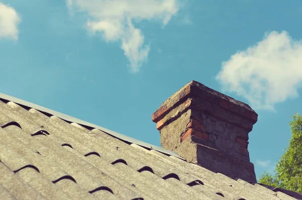 Brick chimney on the rooftop against the sky