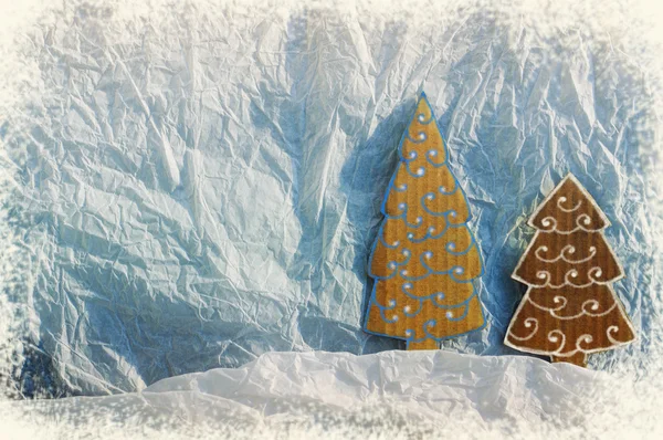 Christmas ornament from paper on textural white crumpled paper. A background for Christmas vacation. A decorative card with Christmas fir trees.