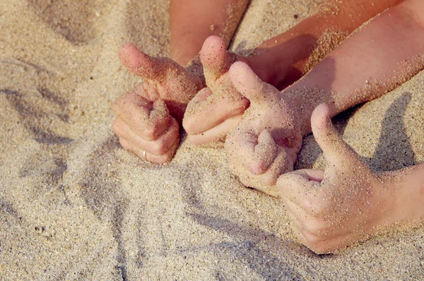 Two couples hands do the sign Like.