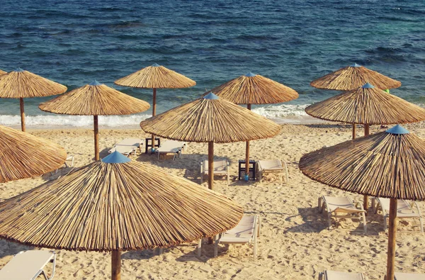 Beach bamboo umbrellas against the sea.
