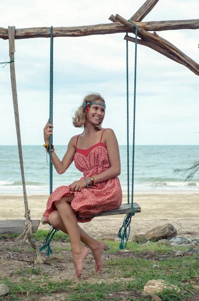 Young Hippie Woman on a Swing Enjoying Summer Day at the Seaside