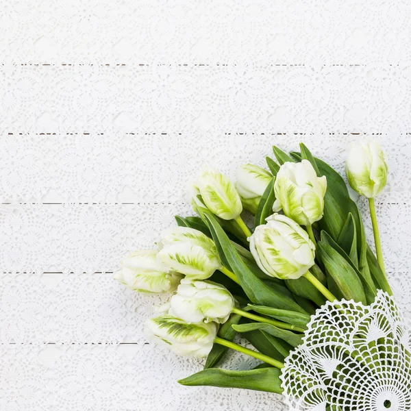 Bouquet of white tulips on white tablecloth.