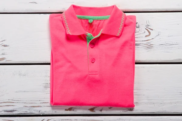 Pink folded polo t-shirt.