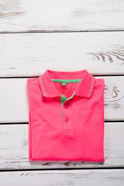 Folded pink shirt with collar.