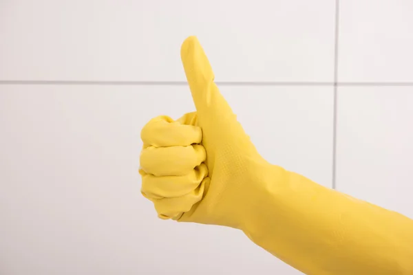 Thumbs up with a yellow rubber glove.