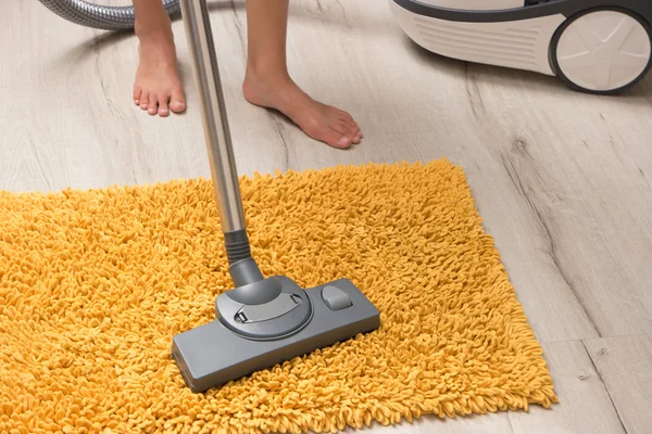 Housewife cleans carpet.