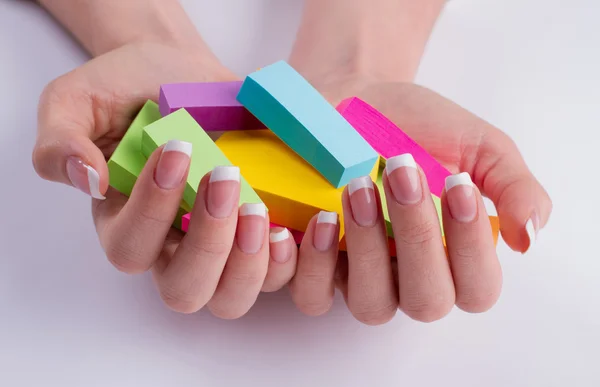 Well-groomed female hands with colored objects.